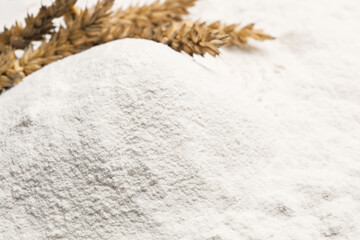 Fototapeta na wymiar Spikes on wheat flour as background, closeup