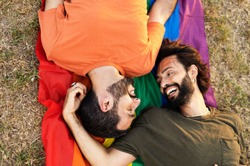  Gay couple embracing and showing their love with rainbow flag. LGBT community.