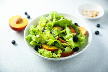 Healthy leaf salad with peach and blueberry