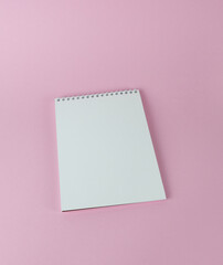Obraz na płótnie Canvas Spiral notebook on a pink background in close-up.