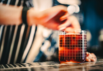 woman hand bartender making negroni cocktail in bar