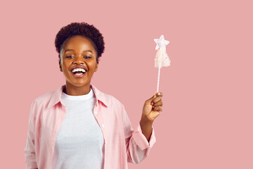Portrait of happy funny modern fairy. Studio shot of joyful positive woman with magic wand. Young...