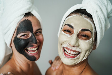 Senior women doing beauty treatment using beauty skin masks - Focus on right female face