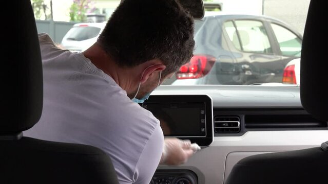 Man cleans vehicule with surgical mask