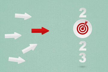 2023 year with target dartboard paper cut and leading red arrow for setup business target concept