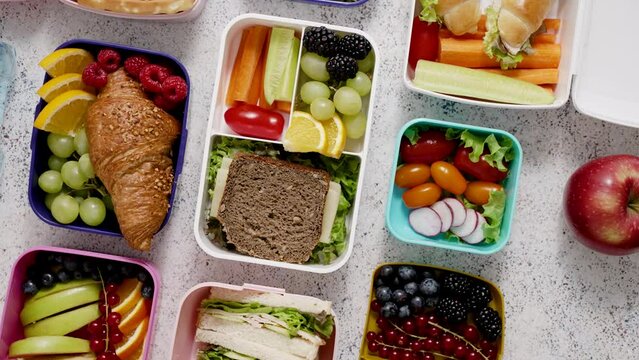Shot of school lunchboxes with various healthy nutritious meals on stone background