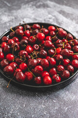 Sweet fresh Cherry on a plate on a stone background