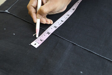 measuring tape measure fabric with white pencil on black fabric