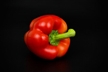 Fresh red pepper on a black background.