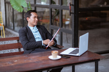 Fototapeta premium asian businessman thinking about business strategy while relaxing in coffee shop