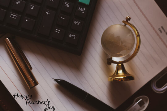 Happy Teacher's day wishes greeting with notebook calculator globe pen conceptual artistic