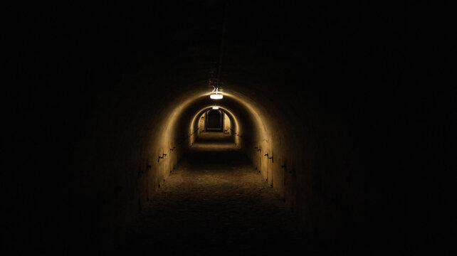 A long dark tunnel of a bomb shelter with a light at the end of the tunnel. Shelter of a bomb shelter in wartime.