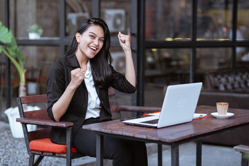 cheerful young woman worker while working outdoor in coffee shop by herself