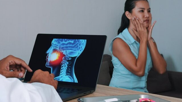 Dentist showing x-ray of mouth on a laptop with woman patient