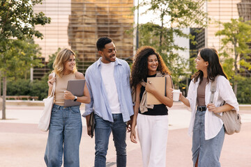 Multiethnic young company spending time together walking outdoors in their spare time. Students go to school wear casual clothes spring. Good mood concept