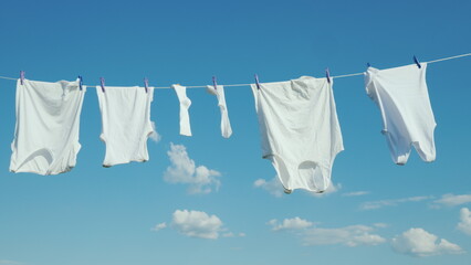 White linen dries on a rope against a clean blue sky