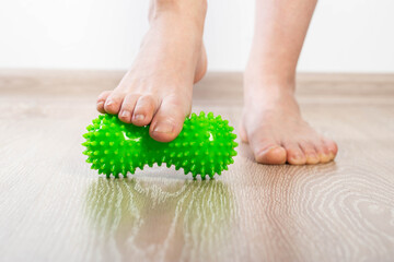 Green medical device for foot massage. Home physiotherapy. Close-up