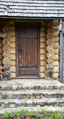 Antique wooden rustic door with wrought iron awnings and stone porch, architecture