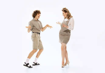 Expressive couple of dancers in vintage retro style outfits dancing social dance isolated on white...