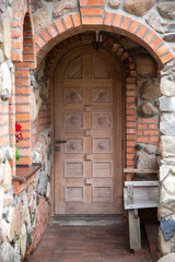 Fototapeta na wymiar semicircular antique wooden door in a brick wall, close-up