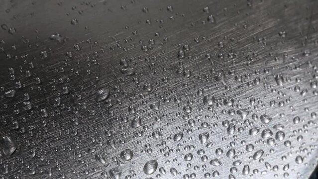 Drops, metal and scratches. Drops of water falling on a scratched metal surface.