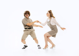 Expressive couple of dancers in vintage retro style outfits dancing social dance isolated on white...