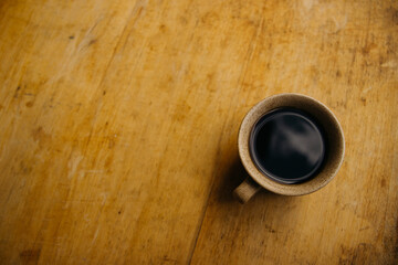 a cup of coffee on the table
morning cup of coffee on an old table
colored cup