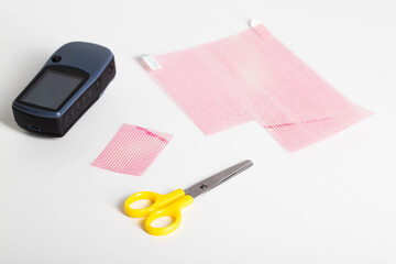Scissors, protective film and navigator on a white background. Protection of the screen of the navigator from scratches and damage