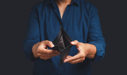 A woman in blue shirt hands opens an empty wallet while standing on a gray background