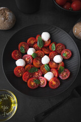 Cherry tomato salad with mozzarella cheese and fresh basil. Delicious vegetarian salad