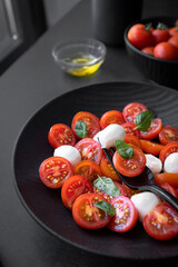 Cherry tomato salad with mozzarella cheese and fresh basil. Delicious vegetarian salad