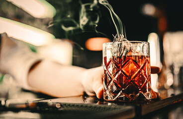 man hand bartender making cocktail glass in bar with smoke