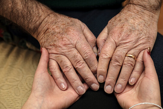 Mani che accolgono, concetto di amore e sostegno persone anziane 