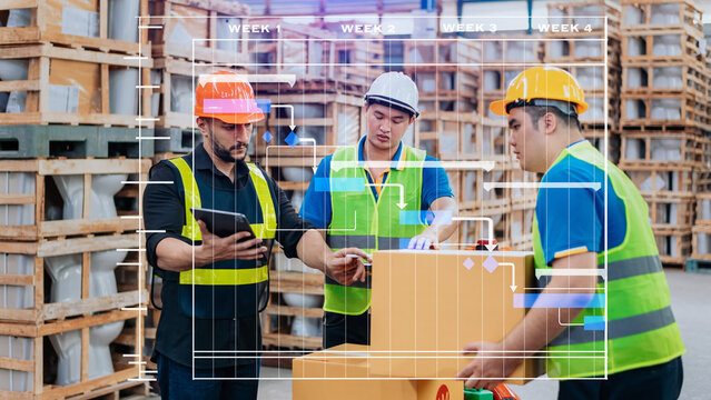 Warehouse manager wearing helmet pointing towards shelf using digital tablet and notepad in warehouse..