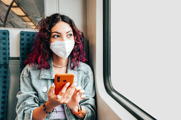 Asian girl wears a facial respiratory mask during the Covid-19 coronavirus pandemic and looks at...