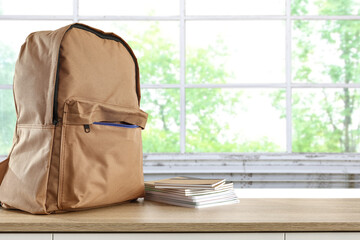 School backpack on shelf and window background. 