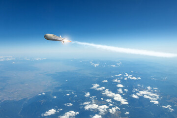 A military rocket flies over the clouds, smoke and fire from the rocket. Concept of missile attack,...