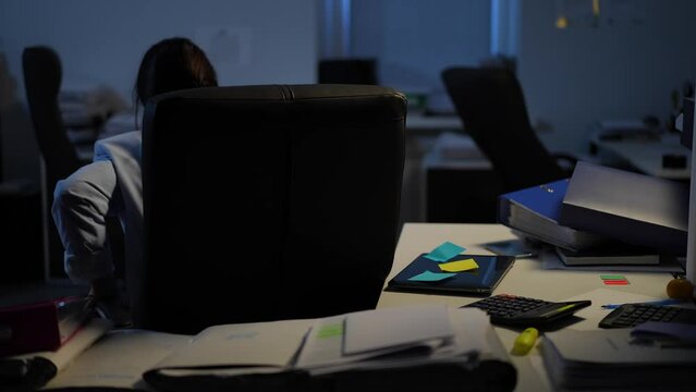 Overburdened Caucasian manager closing laptop leaving dark office indoors. Young tired exhausted woman sighing walking away. Business stress and overworking concept
