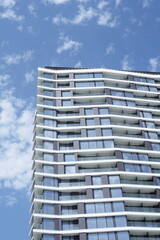 Facade of a modern building with the reflection of clouds on the glass windows