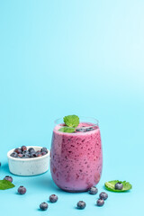 Bilberry yogurt cocktail on a blue background. Natural detox. vertical image. top view. place for text