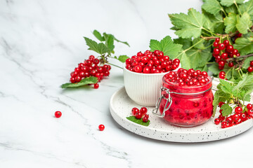 currant jam with fresh red currants on a light background. Homemade jam. Glass jar with red currant jam. Preserved berry