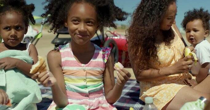 MS Mother and children (12-17 months, 2-3, 6-7) having picnic on beach