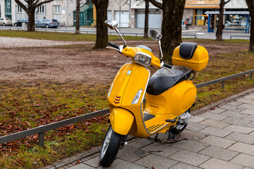 Yellow colored scooter parked in a public garden
