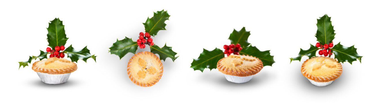 A collection of Christmas mince pies with holly isolated against a flat background.