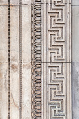 Detail from a wall with ancient Greek style bas relief carvings on marble
