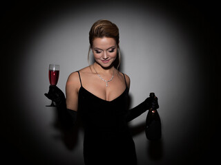 beautiful woman in a black dress with a neckline and long velvet gloves, dancing and holding...