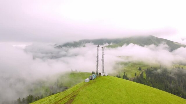 View from drone to GSM tower and radio communications in mountains in clouds. Cell tower. Base transceiver station. Wireless communication antenna transmitter. Bakhmaro, Georgia