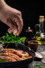 Delicious shrimp with seasoning, Prawns fried with splashes of lemon juice in a freeze motion on a dark background. Seafood appetizer. Culinary, cooking concept
