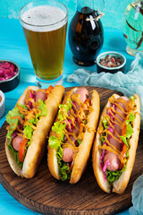 Hot dog with lettuce, tomatoes and pickled onions. Grilled bun with sausage