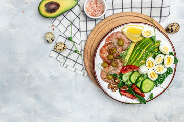 Ketogenic diet breakfast shrimps, prawns, soft fried egg, fresh salad, tomatoes, cucumbers and avocado on a light background. Keto, paleo lunch. Long banner format. top